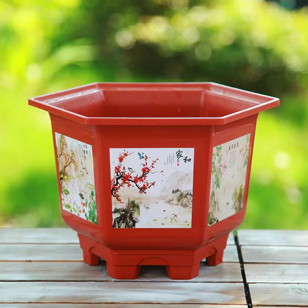 Red resin flower pot with illustrated front panel and flared feet, empty for planting.