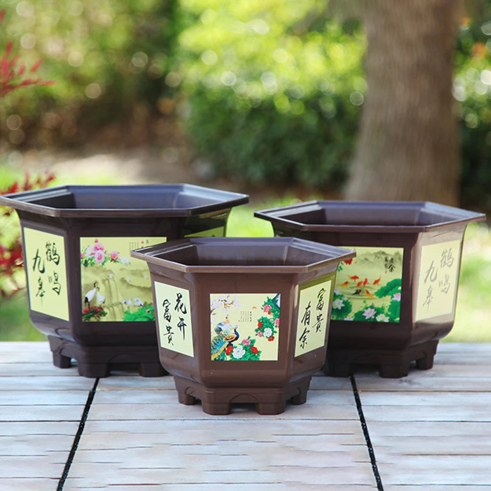 Set of four dark planters with decorative panels and wide bases