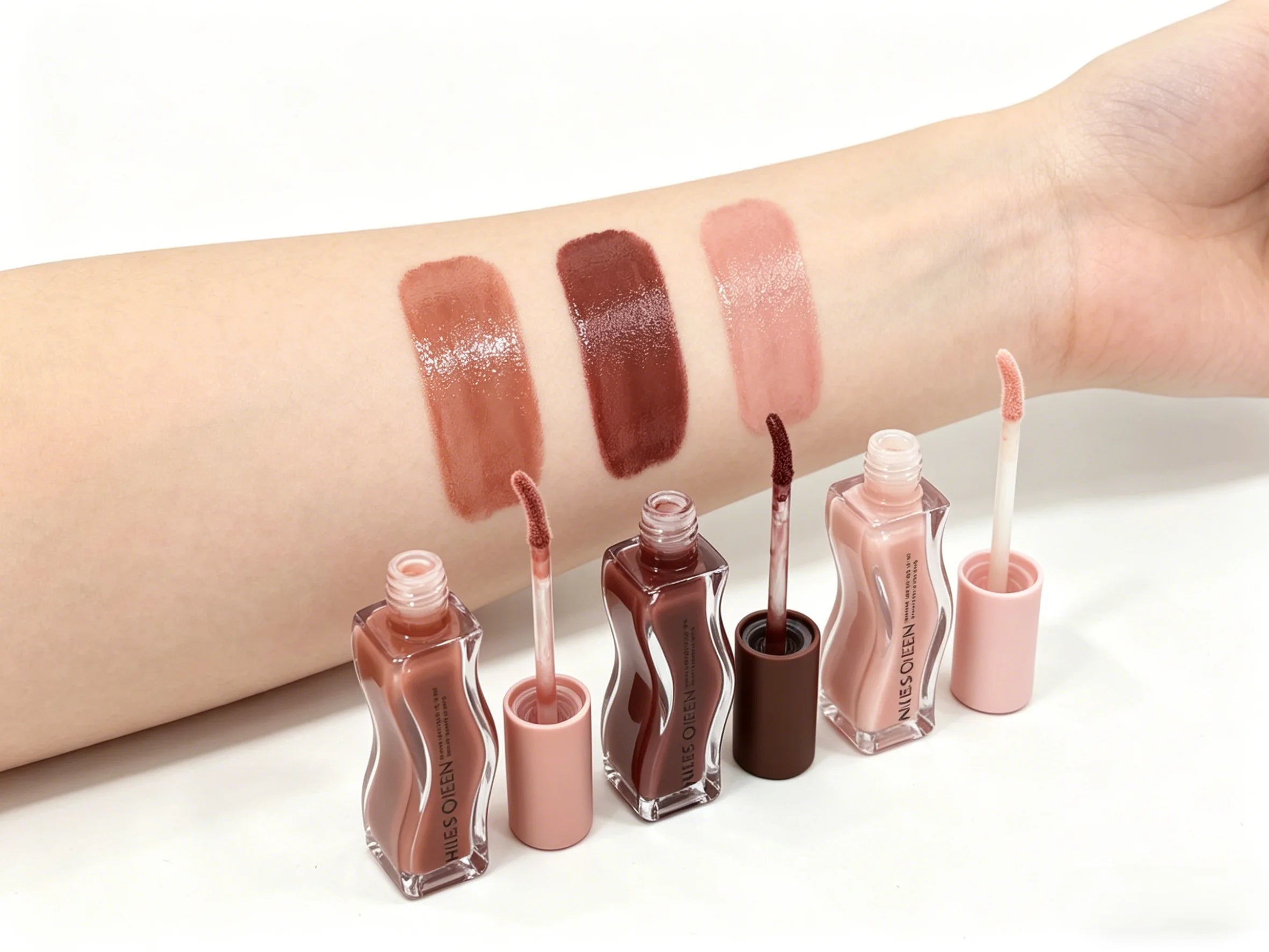 3-color moisturizing lip gloss set with hydrating, shiny finish and swatch on arm in nude, brown, and pink shades.