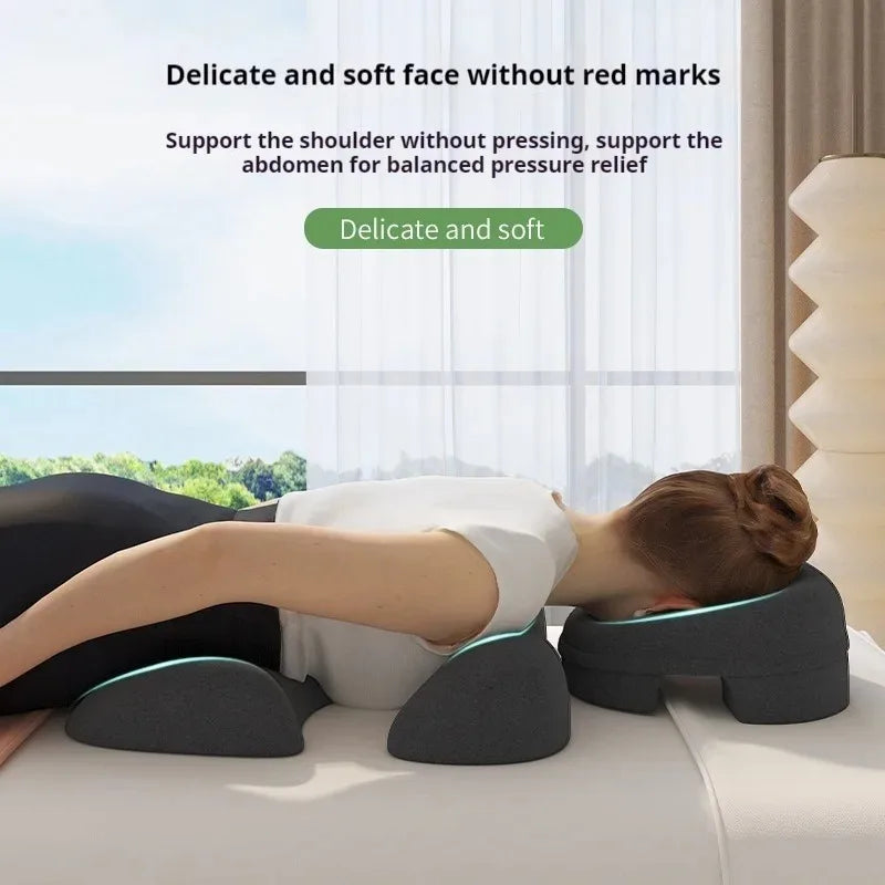 Woman lying prone on a dark gray, multi-part foam massage cushion system designed for face, shoulder, and chest support.
