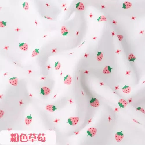 White organic knit jersey fabric featuring a small pink strawberry and floral print for children's clothing.