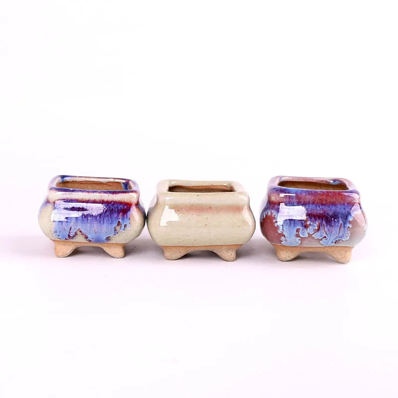 Three mini ceramic succulent pots: blue, beige, and purple-blue with speckled glaze