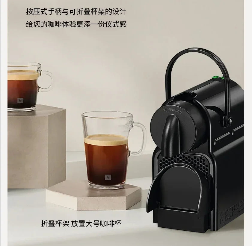 Matte black Nespresso coffee machine with foldable cup support and metal lever, styled with glass coffee cups.