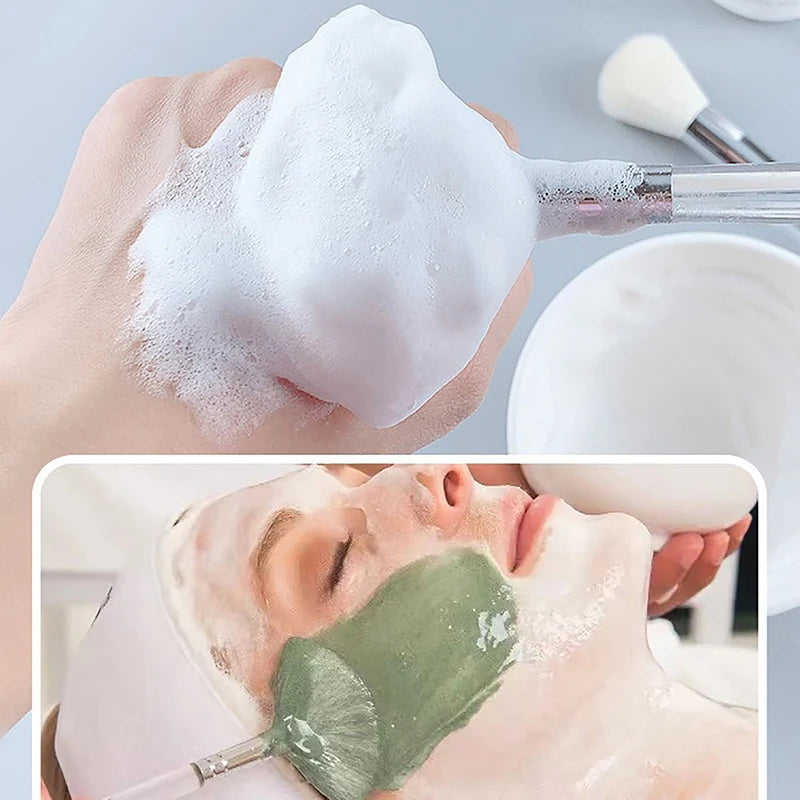 Soft facial cleanser brush and mask applicator tool applying lather and green face mask to skin for skincare routine.