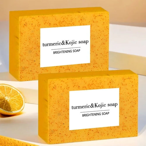 Anti-inflammatory turmeric and kojic brightening soap bars in yellow packaging, set of two.