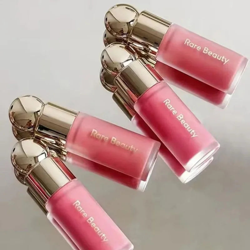Rare Beauty Soft Pinch Liquid Blush in frosted glass bottles with gold caps, showing vibrant pink and coral liquid makeup.