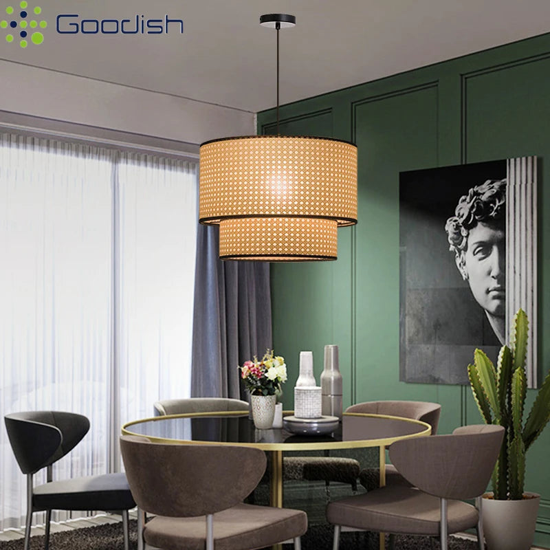 Two-tiered cylindrical pendant light with beige woven rattan shade and black trim, suspended over a dining table.