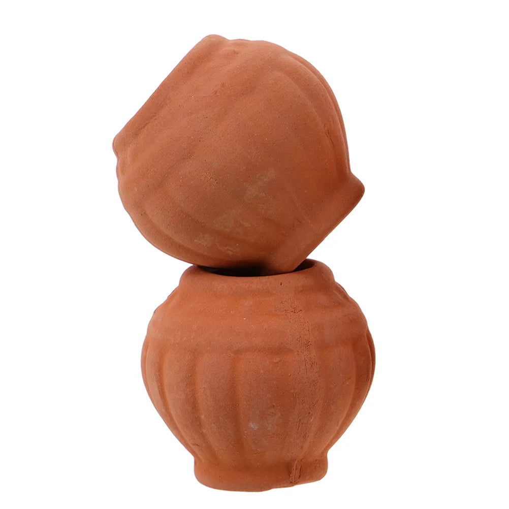 Small terracotta clay planter pot with rounded base and drainage hole