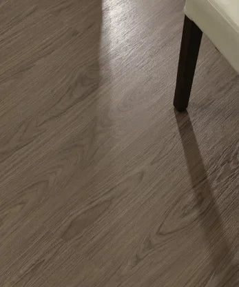 SPC click flooring plank close-up with dark gray-brown wood-look grain
