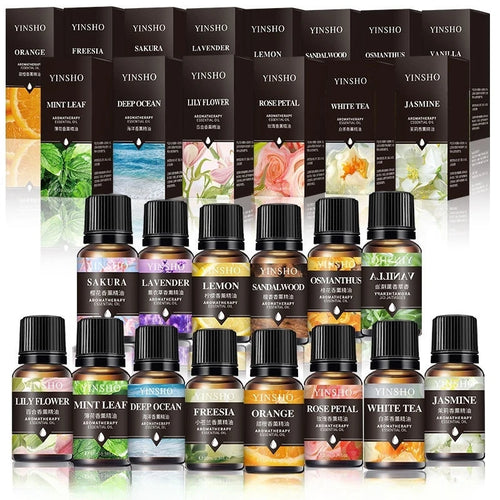 Set of YINSHO essential oils in amber glass bottles for aromatherapy, featuring various floral and fruit scents.