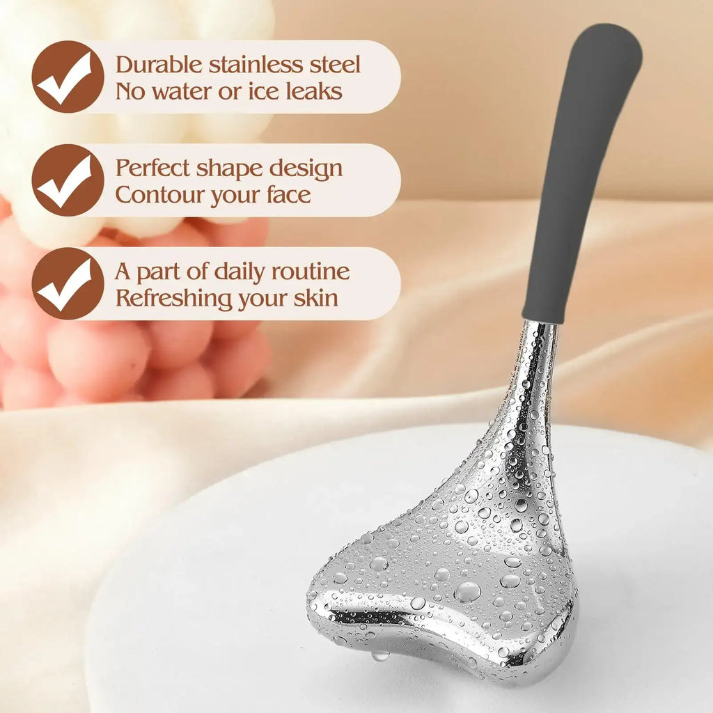 A silver, triangular stainless steel Gua Sha cryo tool with a grey handle, covered in water droplets on a white base.