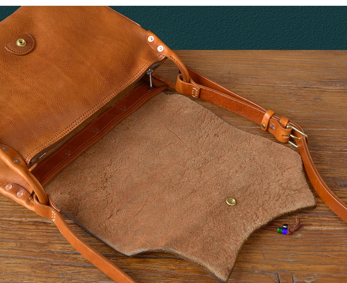 Vintage handmade tan genuine cowhide leather messenger bag with buckle strap, exposed raw suede interior and snap lock.