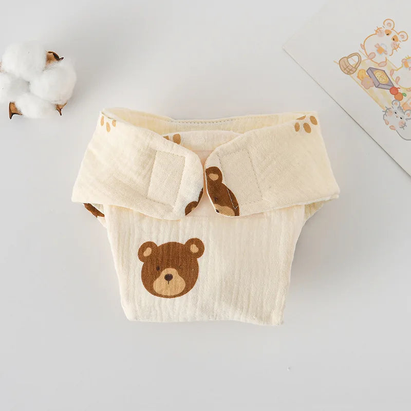 Cream muslin baby diaper cover with cute brown bear print and Velcro closure. Breathable baby care essential.