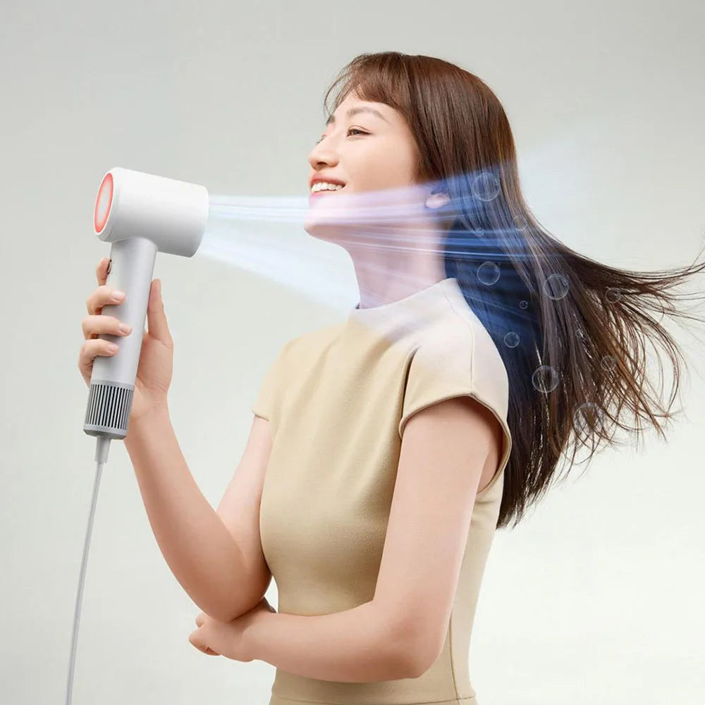 Woman using white MIJIA H501 SE high-speed ionic hair dryer for fast, professional hair drying with powerful airflow.