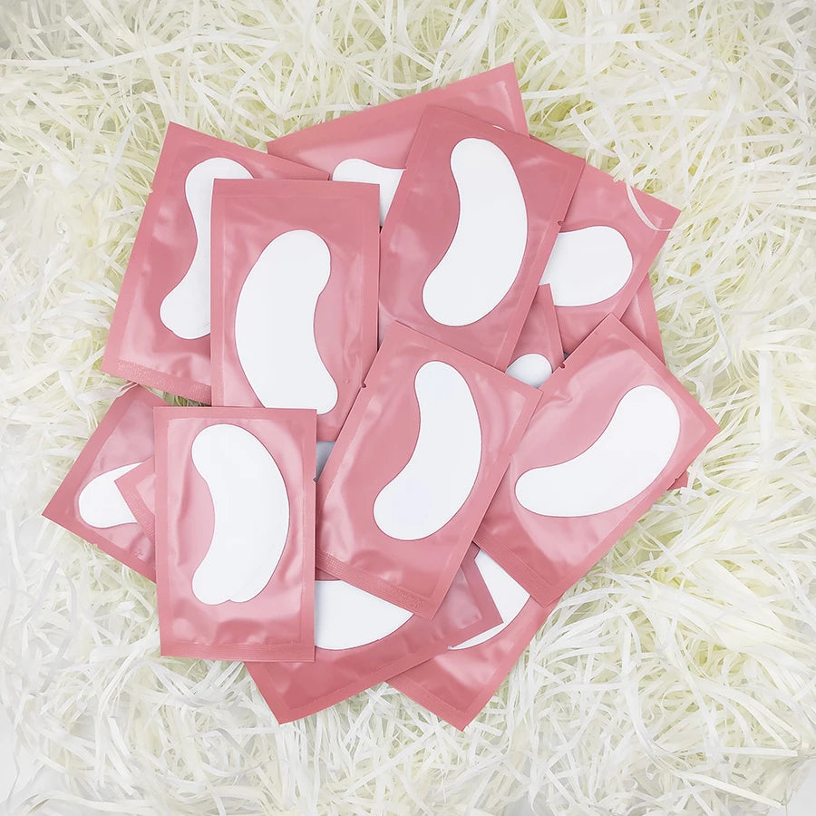 Pink lint-free eyelash extension gel pads in individual sachets for under-eye care and lash application.