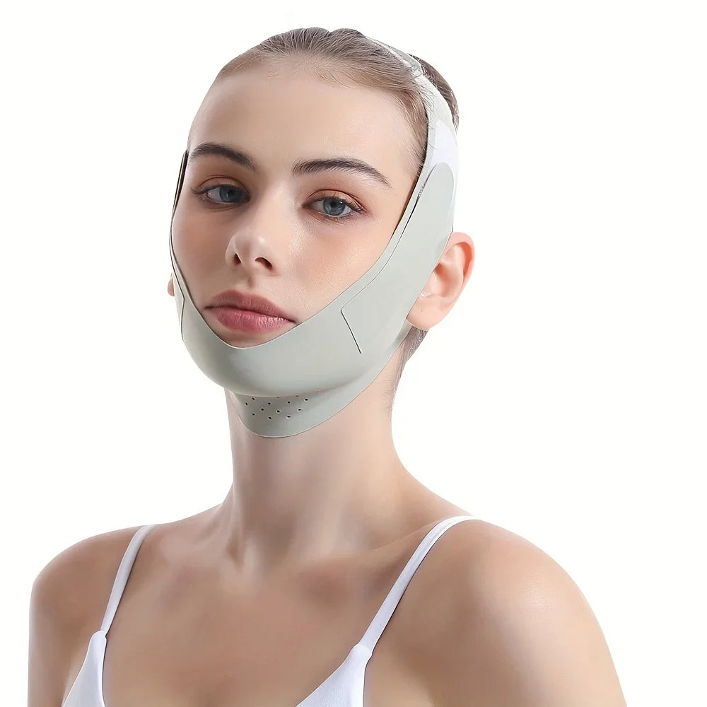 A woman wearing a smooth, sage-green, perforated V-line face slimming bandage strap under her chin.