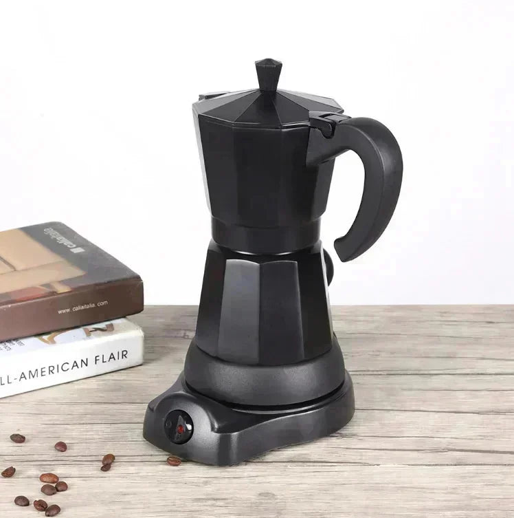 Matte black electric moka pot coffee maker with octagonal base on a wooden table with scattered coffee beans.
