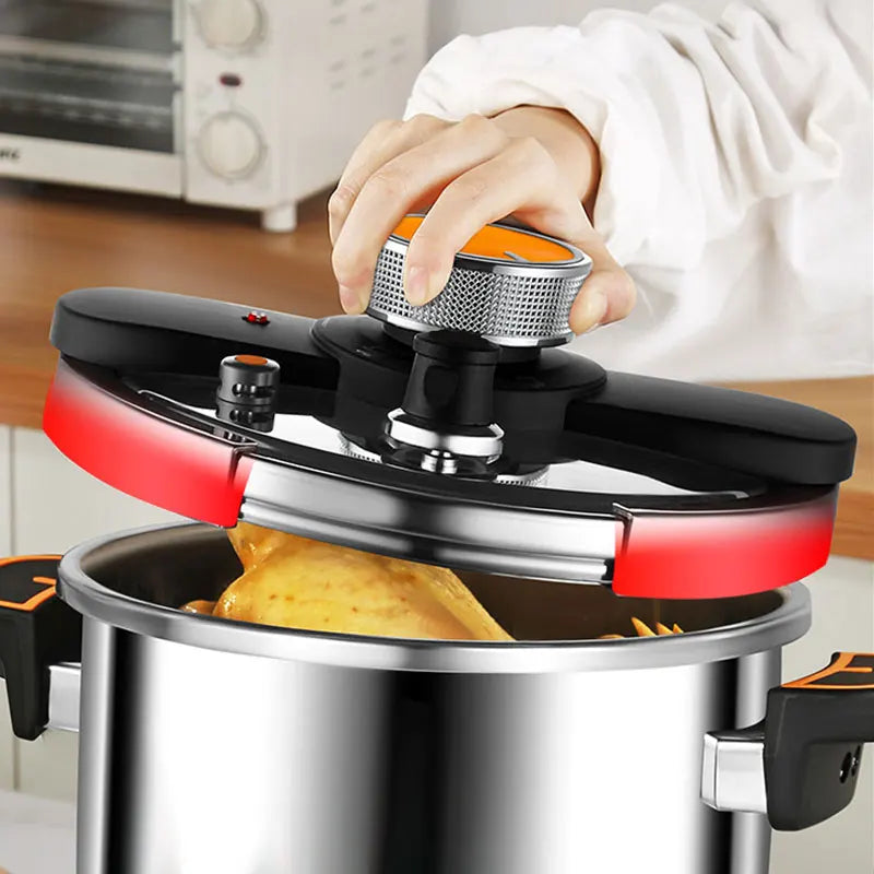 Stainless steel pressure cooker with hand lifting black lid and orange safety cap