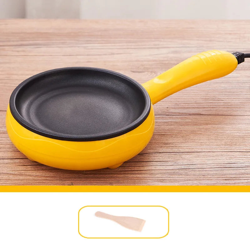 Yellow electric egg cooker mini nonstick frying pan with round black cooking surface