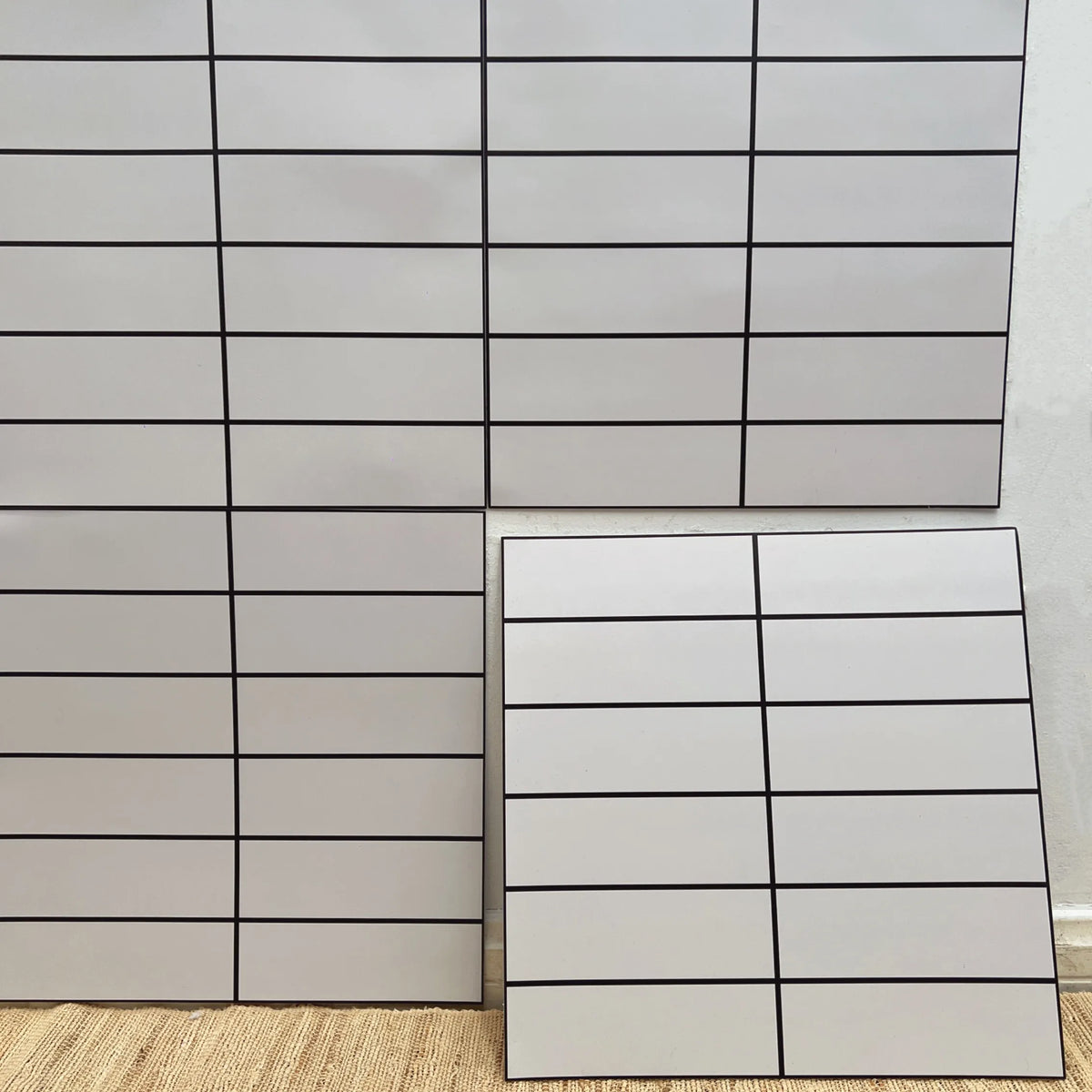 Peel-and-stick marble tile backsplash sheet with clean white rectangular grid tiles
