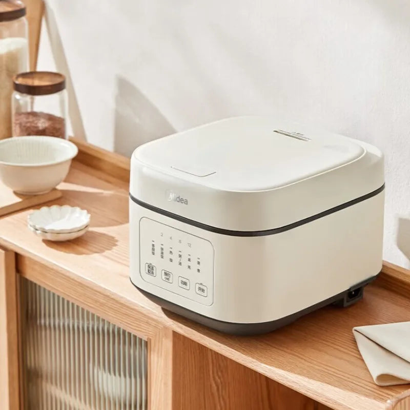 White Midea rice cooker on countertop with closed lid and front control panel