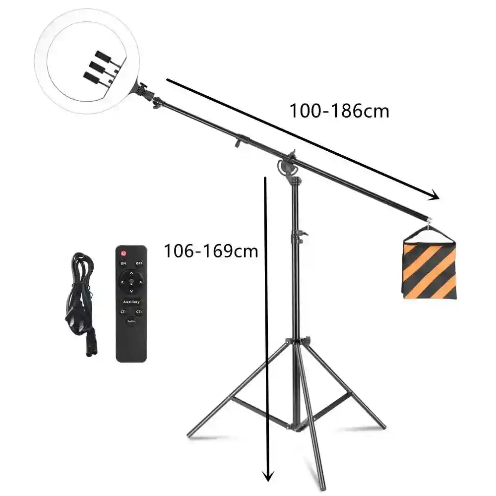 Black ring light on boom stand with counterweight bag, remote, and power cord. Adjustable height and extension arm.