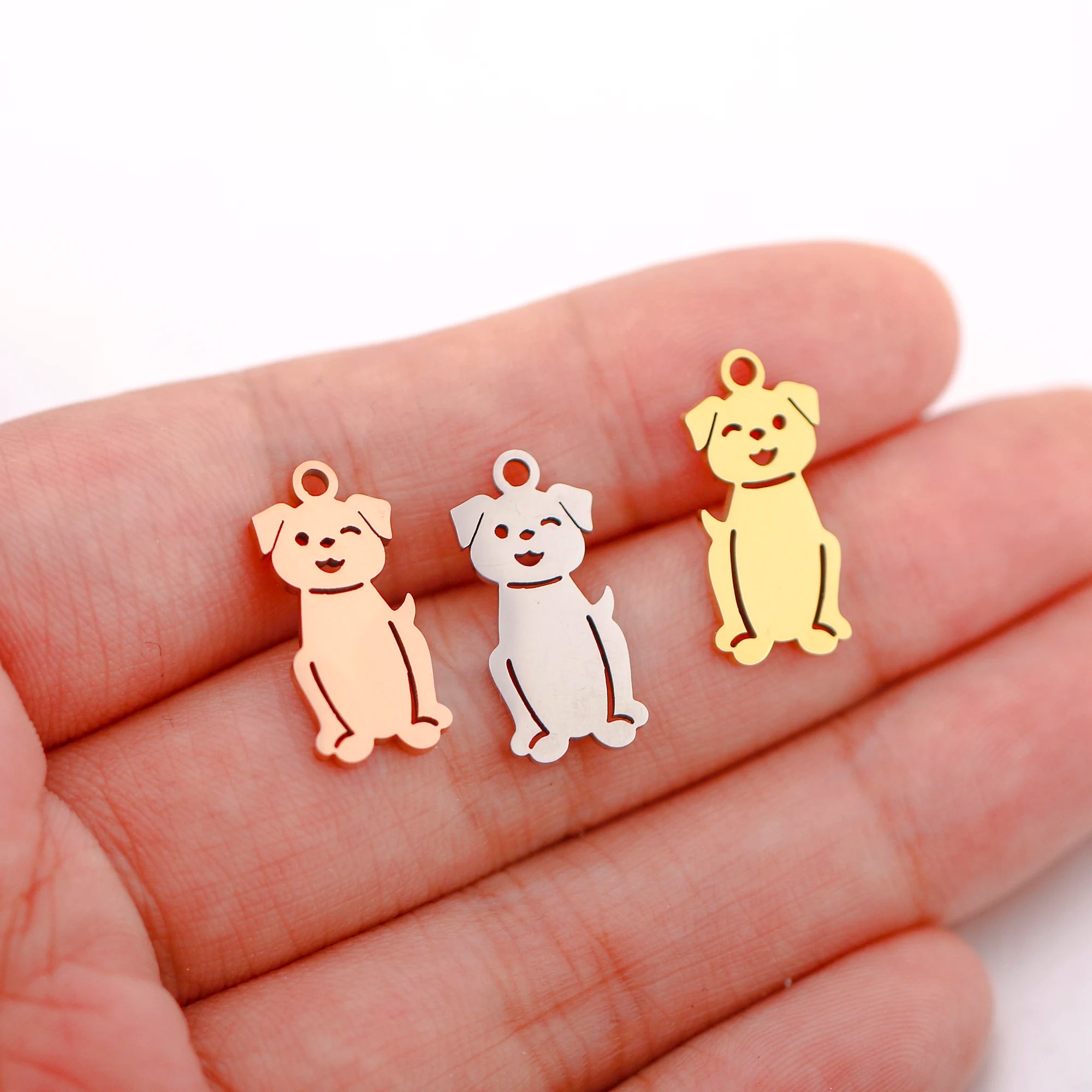 Three stainless steel dog charms in gold, silver, and rose gold for DIY pet-themed jewelry making.