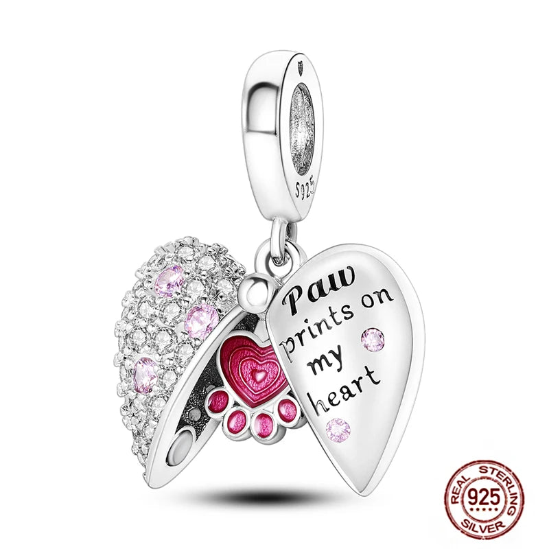 Sterling silver paw print heart charm for charm bracelets featuring pink crystals and "Paw prints on my heart" engraving.