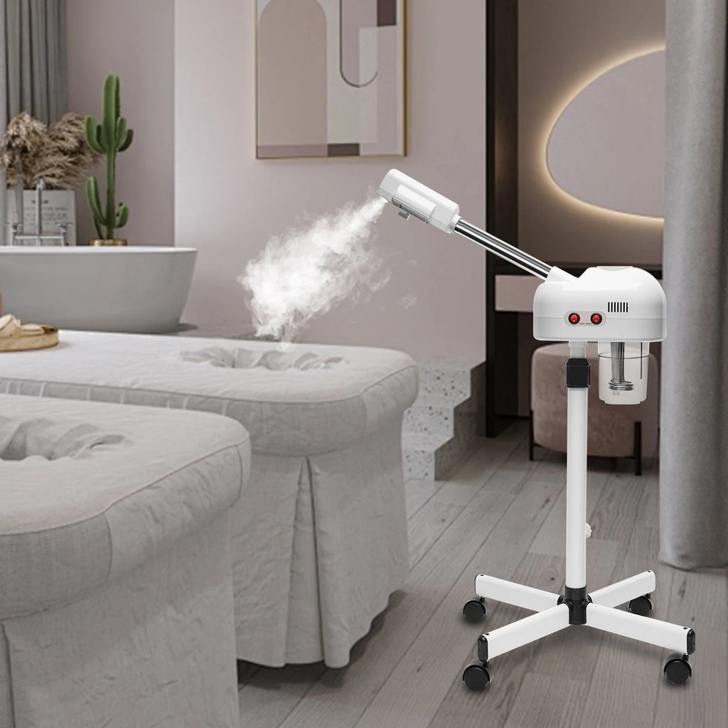 White 800W professional facial steamer on wheels with 750ml tank, emitting steam in a modern spa treatment room.
