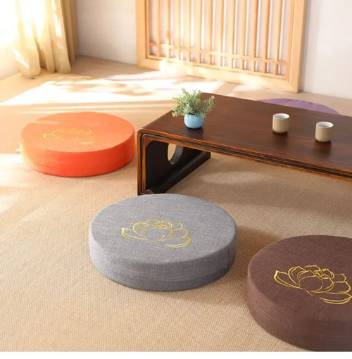 Round linen meditation cushions in orange, grey, and brown for mindful zen practice with lotus embroidery.