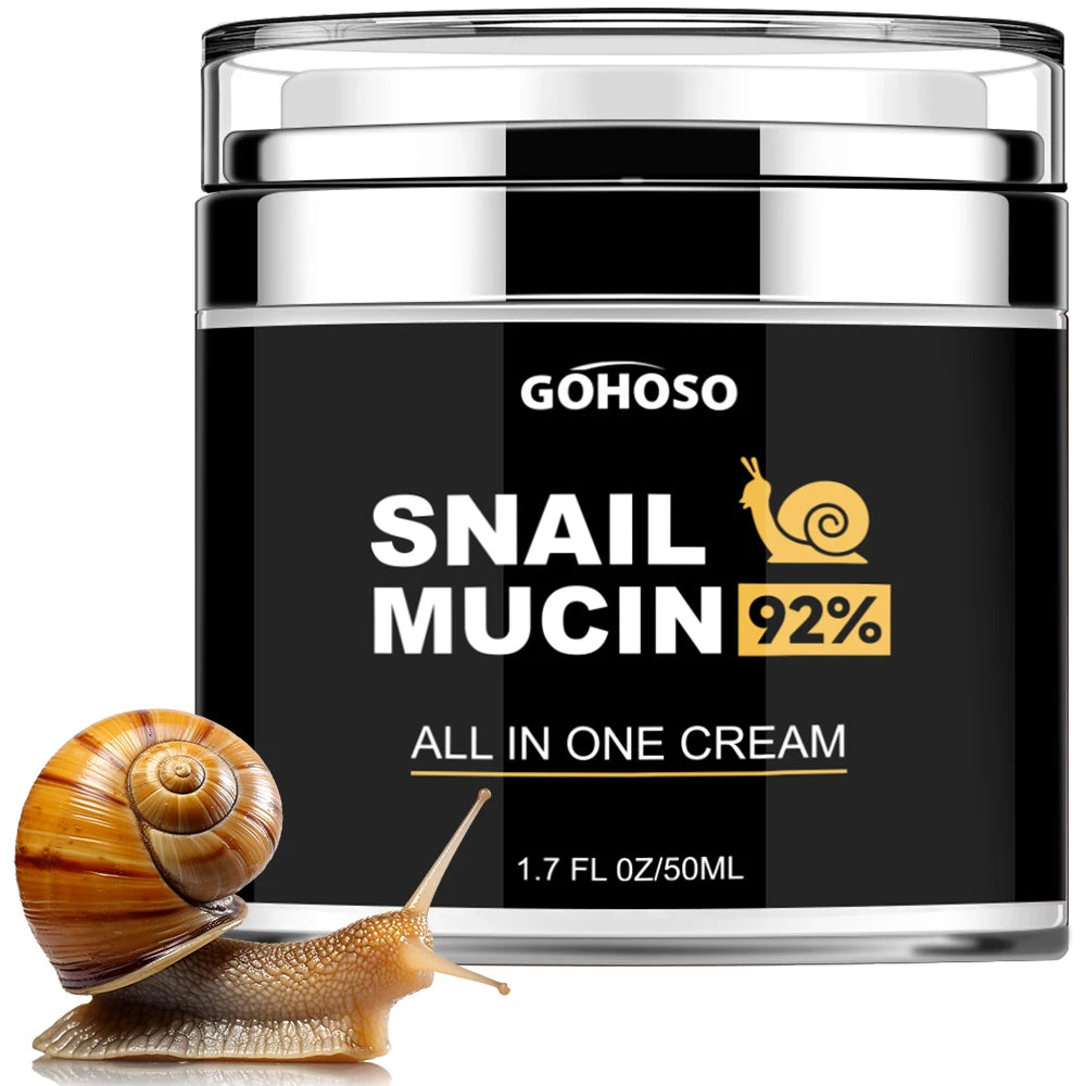 A cylindrical black and silver jar of snail mucin cream next to a small garden snail.