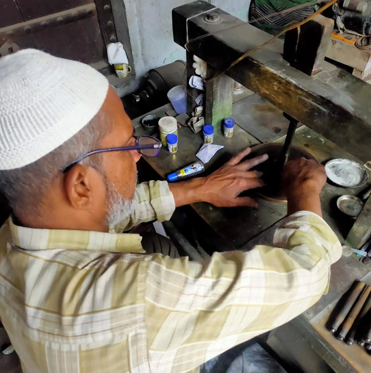 Jewelry workshop worker using polishing tools at a workbench
