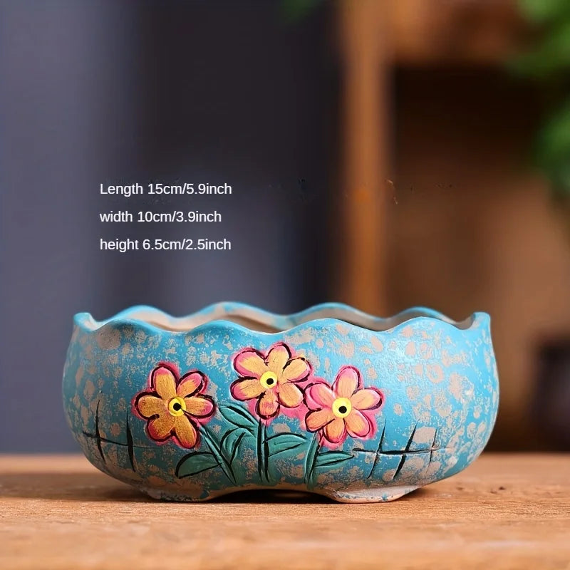 Turquoise ceramic oval flower planter with three hand-painted daisies and green leaves