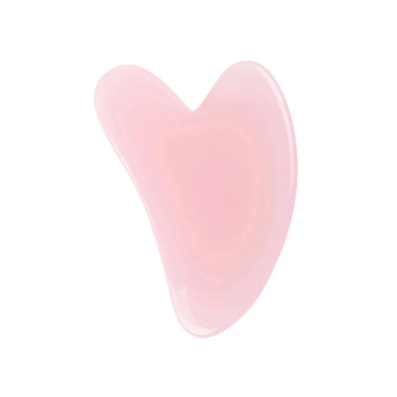 A smooth, translucent light pink heart-shaped resin gua sha massage tool on a white background.