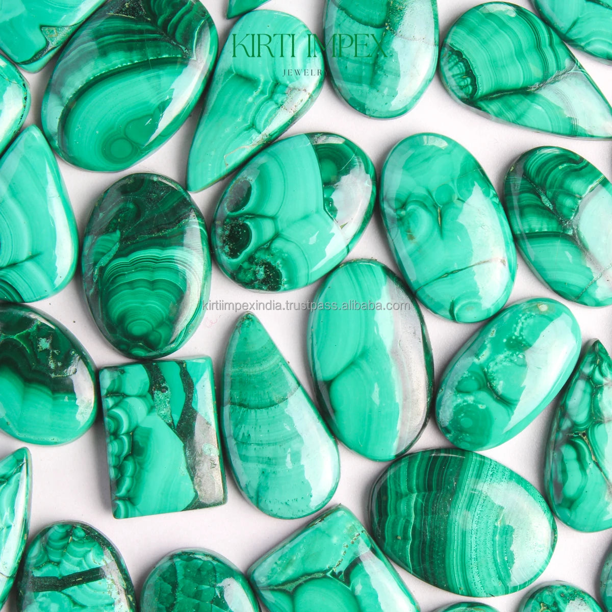 Assorted green malachite oval cabochons showing banding and swirls, loose gemstone pieces