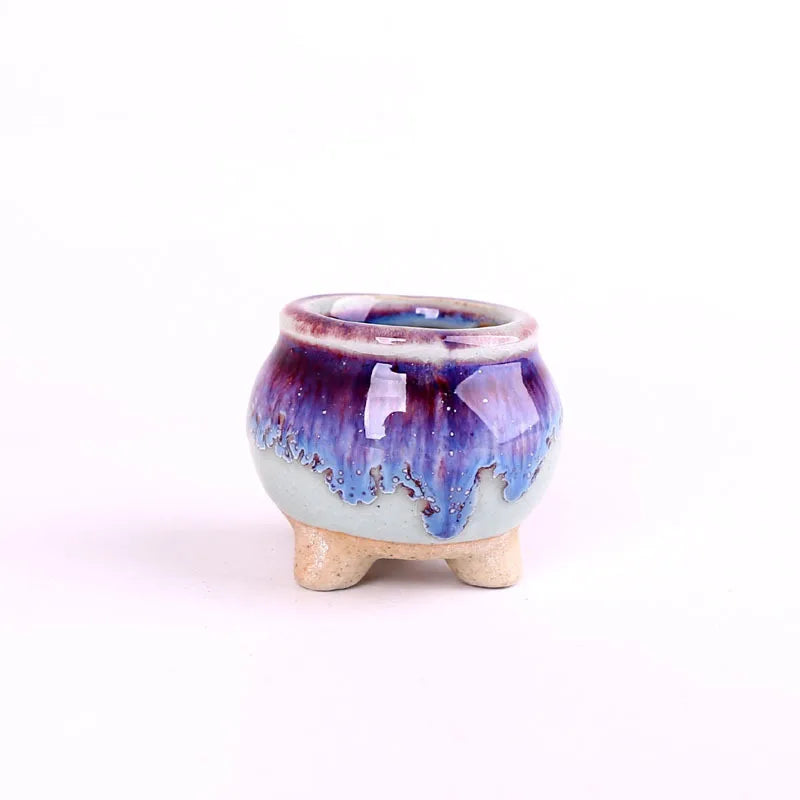 Mini ceramic flowerpot for succulent, purple-blue crackle glaze with red rim, small tripod base.