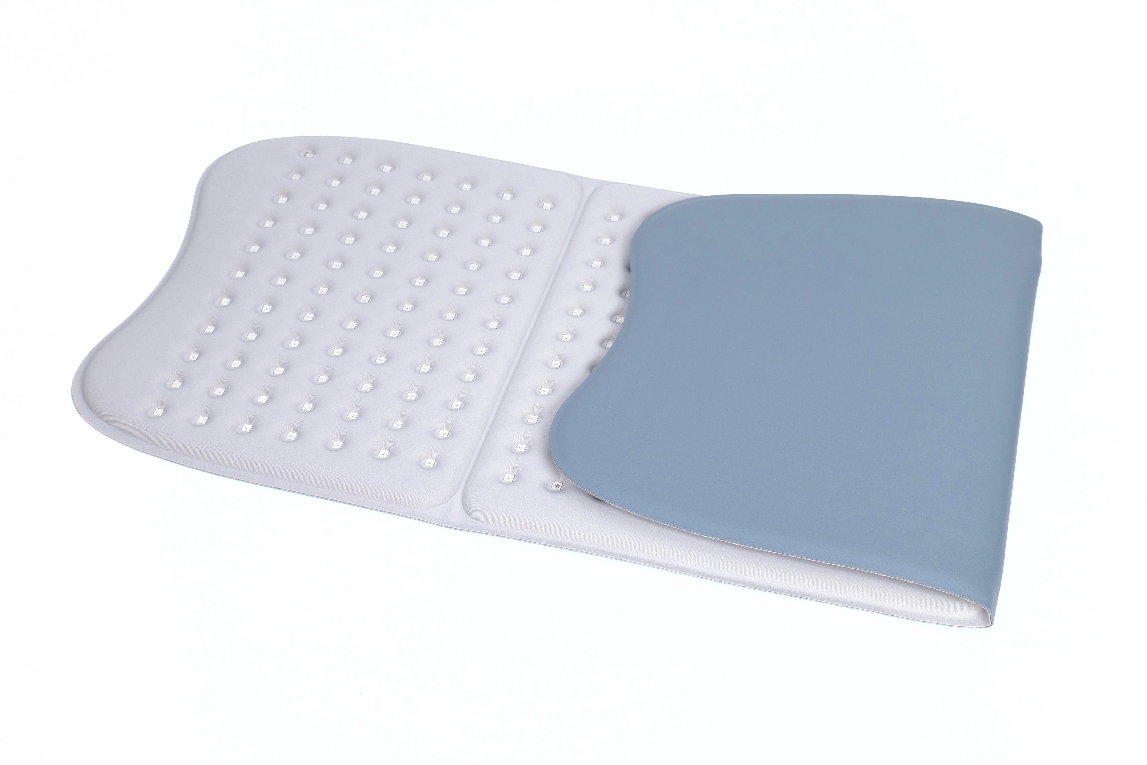 Large, flexible, white red light therapy mat with numerous LED bulbs, partially folded with a blue-grey outer surface.