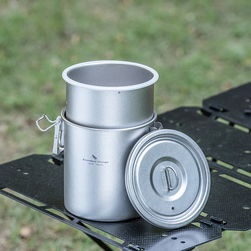Titanium cook pot with flat lid resting beside it on a camping mat