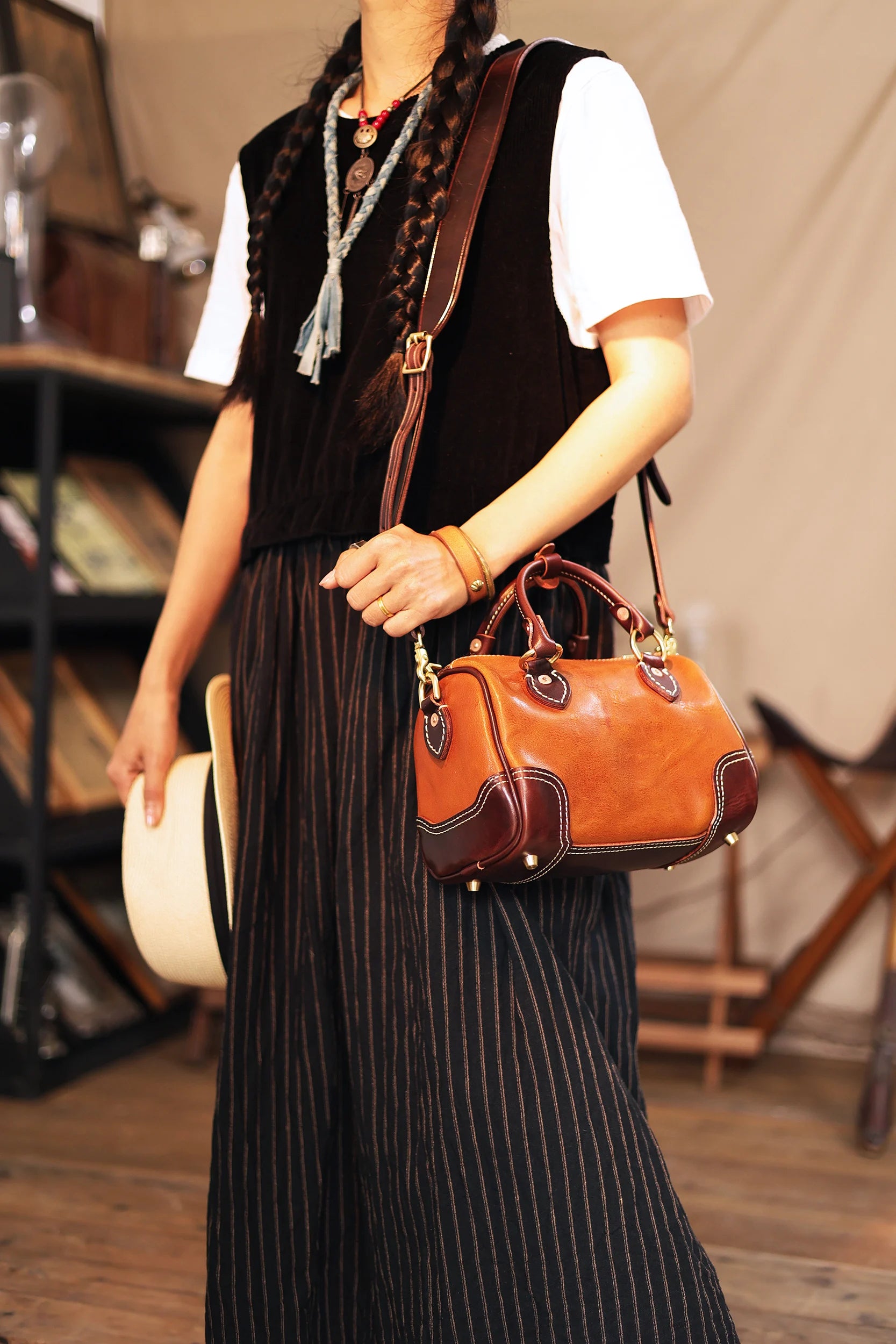 Vintage designer small brown leather shoulder bag, handmade cowhide barrel handbag with dark contrast trim detailing.