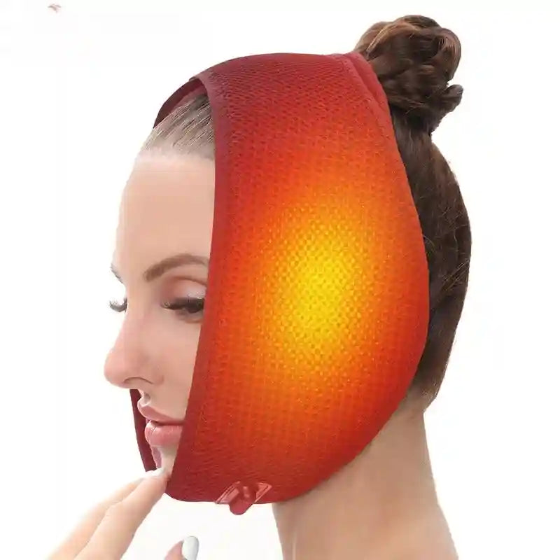 A woman wears a red, mesh, adjustable heated chin and jaw wrap that glows yellow in the center.