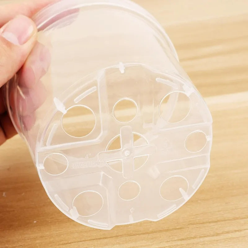Close-up of clear plastic pot base with drainage hole inserts and cross-support ribs