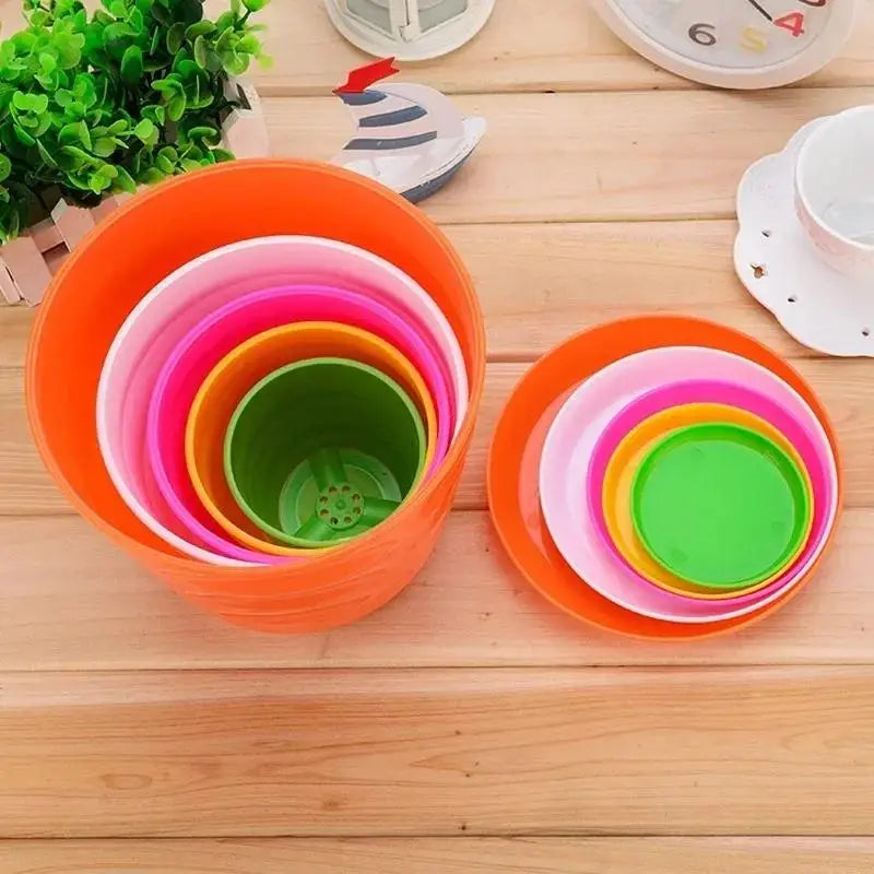 Nested orange plastic flower pots with rainbow-colored inner pots