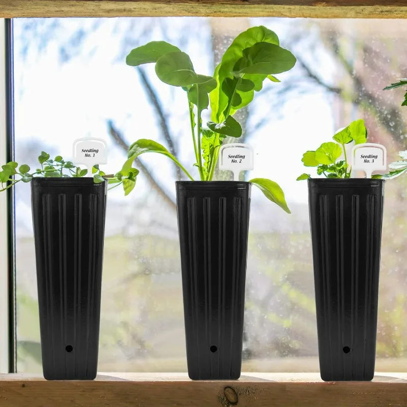 Three black ribbed plastic seedling pots with drainage holes on a windowsill