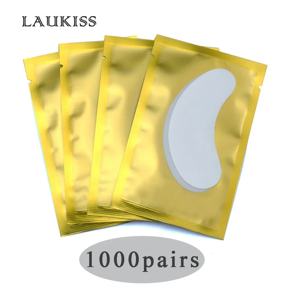 White gel eyelash extension under eye patches in metallic gold individual foil packaging.