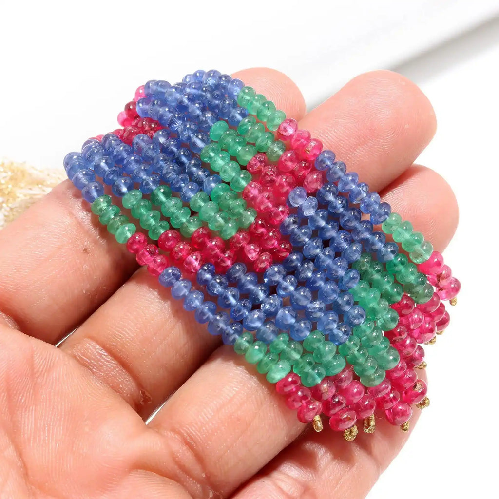 Close-up view of 4mm smooth rondelle beads strand in blue, green, and pink.