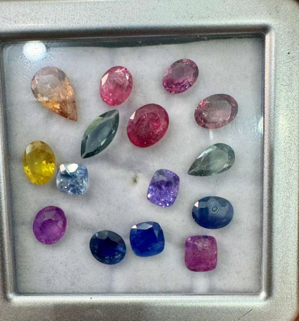 Natural sapphire gemstone mix with oval, cushion, and round faceted stones in metal tray