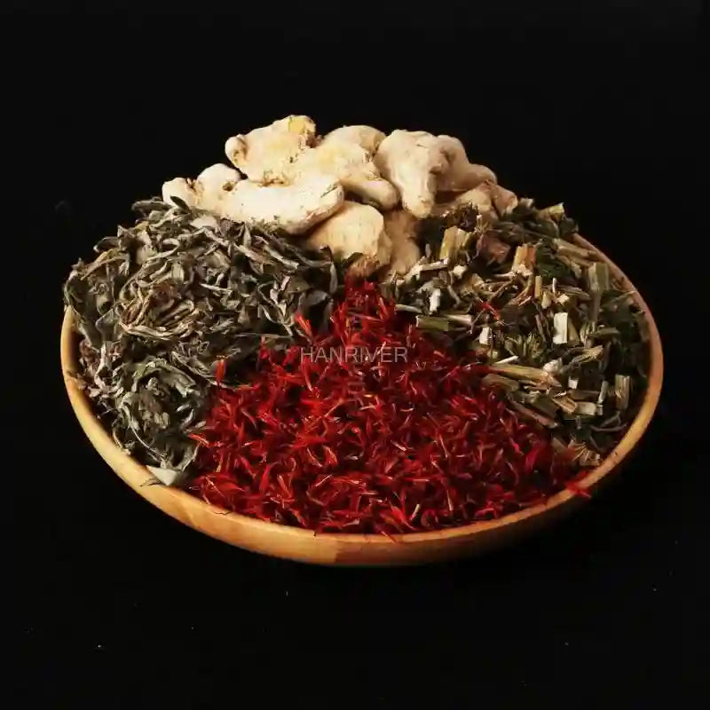Bowl of Chinese herbal foot soak ingredients: dried ginger, wormwood, safflower, and motherwort for spa bath therapy.