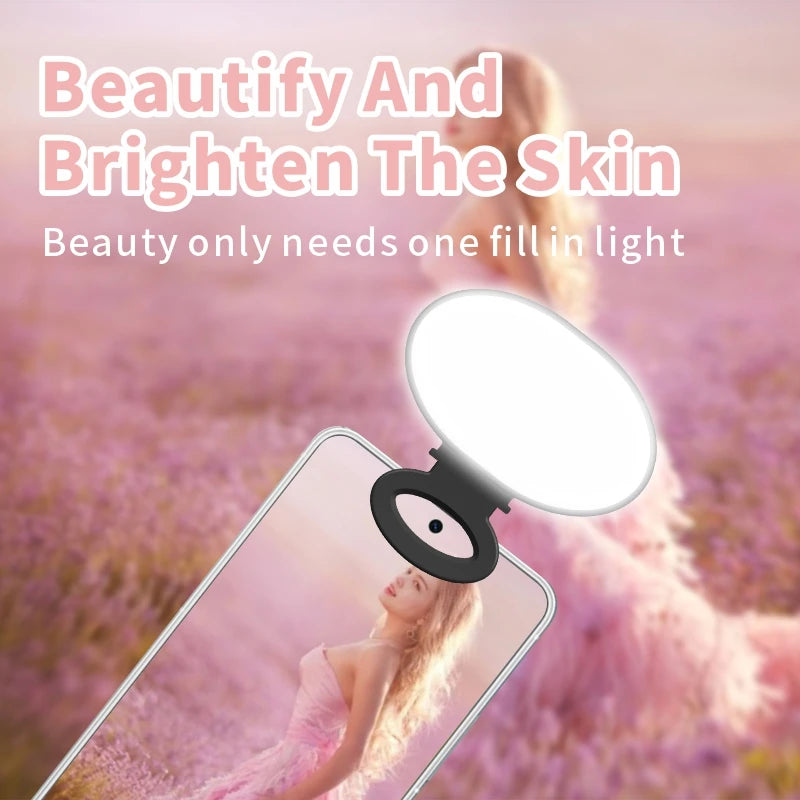 Clip-on white oval LED ring light for smartphones, used for brightening faces during photos and videos.