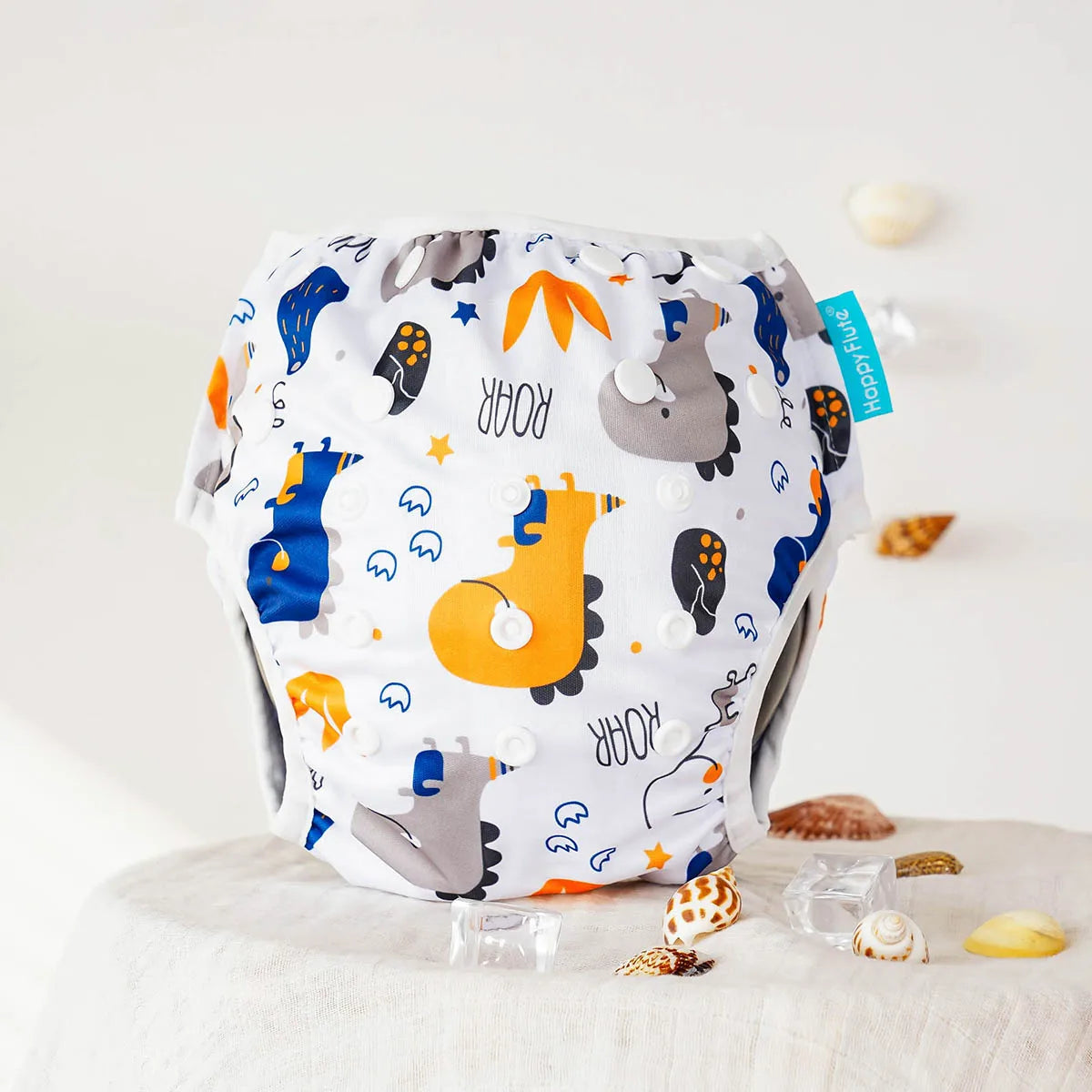 Happy Flute reusable cloth baby diaper with dinosaur print and adjustable snap buttons.