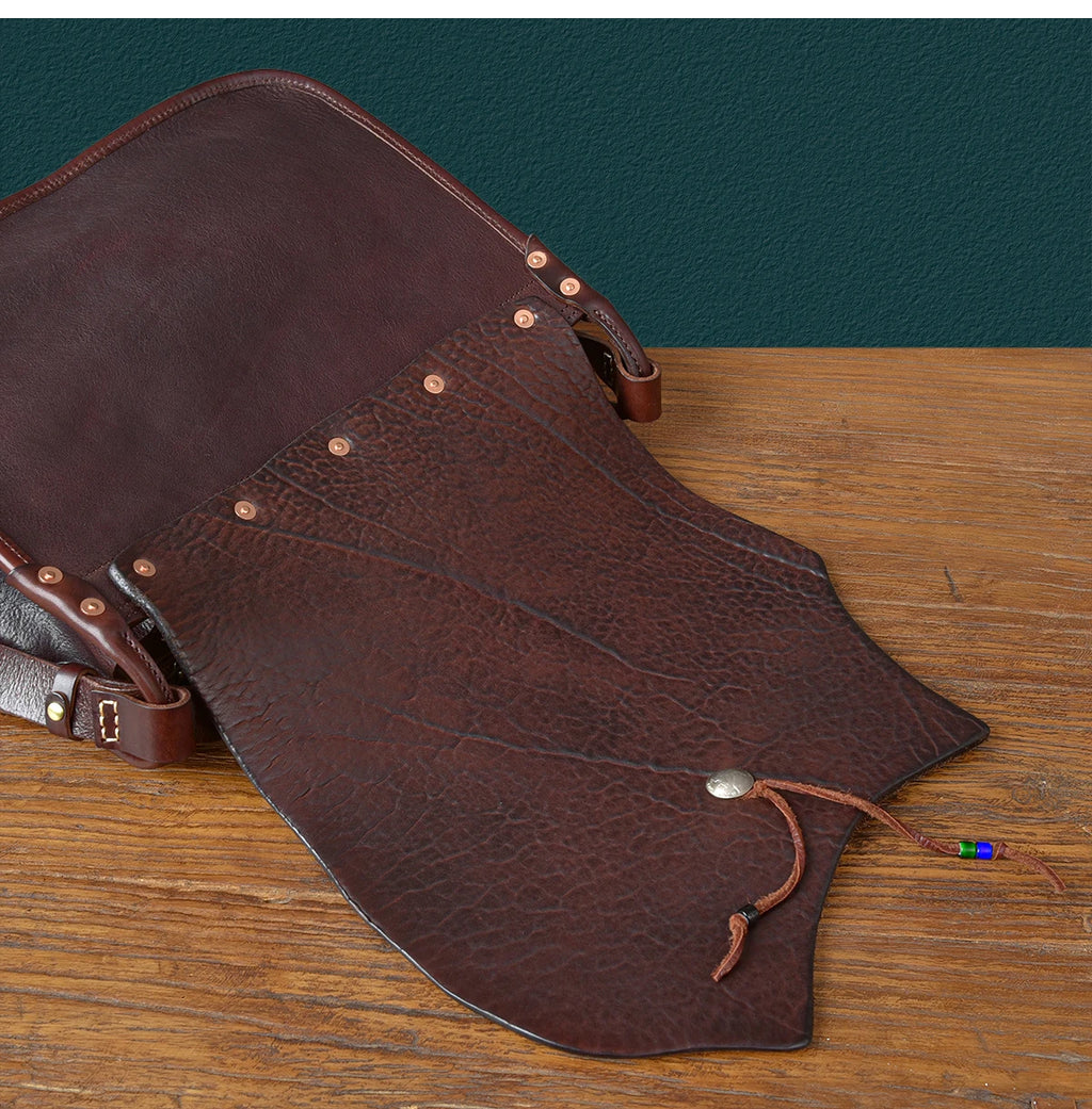 Vintage dark brown genuine cowhide leather messenger bag with rivet details, asymmetrical flap, and bead accent.